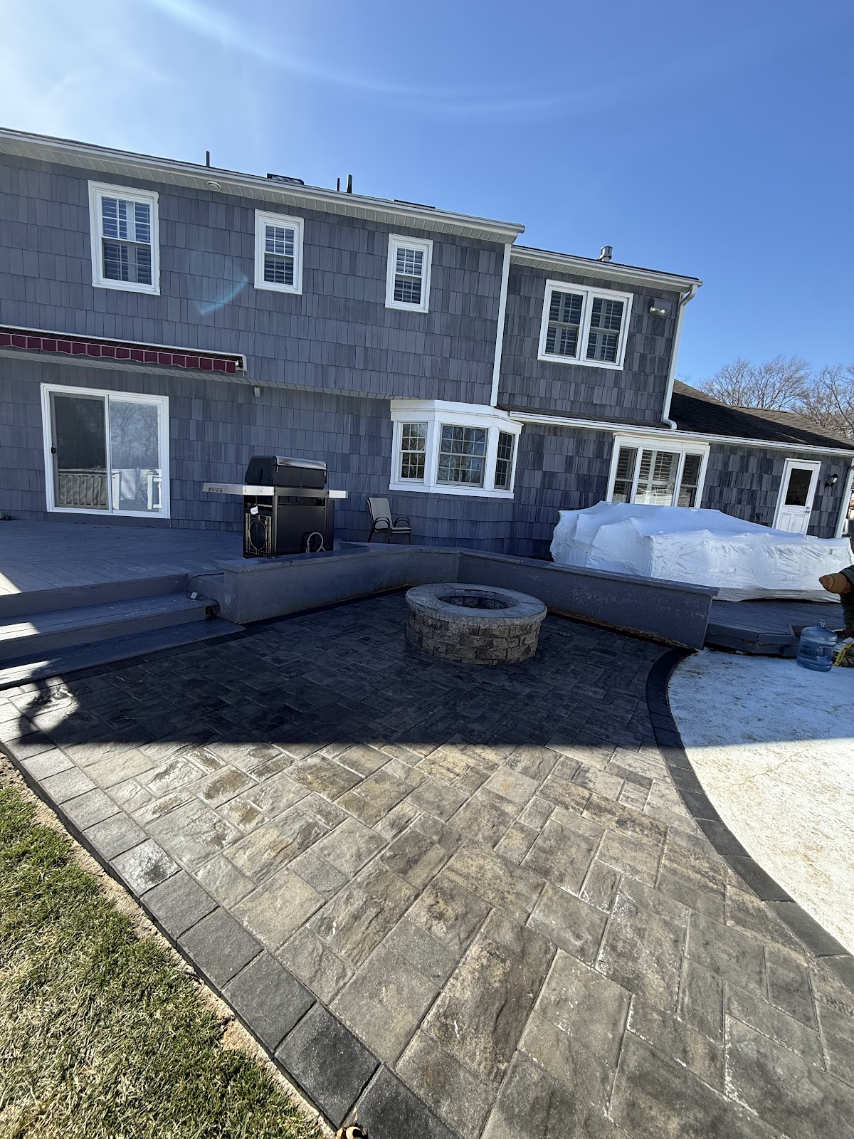 Finished stone patio with a built-in fire pit and seating wall